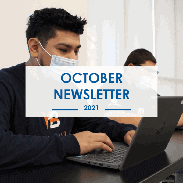 Two people wearing masks work on laptops at a table. Overlaid text reads October Newsletter 2021.