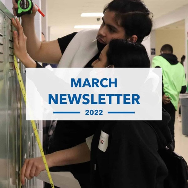Two students measure a locker with a tape measure in a school hallway. The text overlay reads, March Newsletter 2022. Other students are visible in the background.