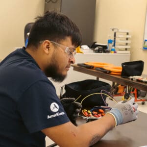 Trainee Jovanny learning to fix an electrical outlet