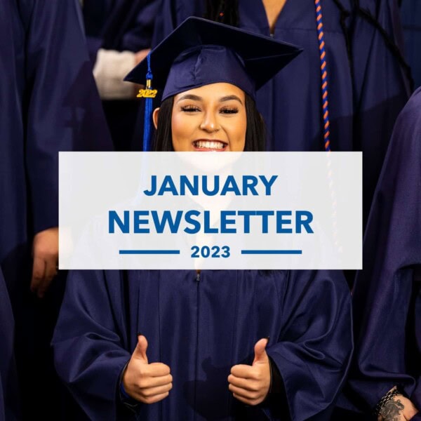 A graduate in a navy cap and gown smiles and gives two thumbs up; the text overlay reads “January Newsletter 2023.” Other graduates in navy gowns stand in the background.
