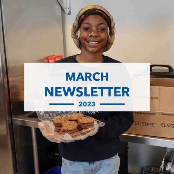 A smiling person wearing a hairnet and dark shirt holds a container of cookies in a kitchen. Overlaid text reads: March Newsletter 2023.