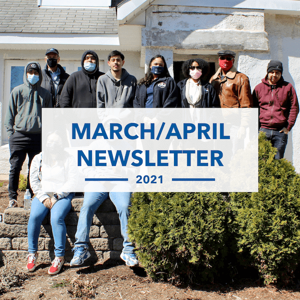 A group of nine people poses outside a building, some wearing masks. Over the image, text reads: March/April Newsletter 2021. Small shrubs and a raised stone bed are in the foreground.