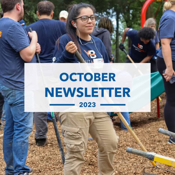 A group of people wearing blue shirts and working outdoors with tools, possibly volunteering for a community project. In the center, a woman holds a rake. Overlaid text reads October Newsletter 2023.